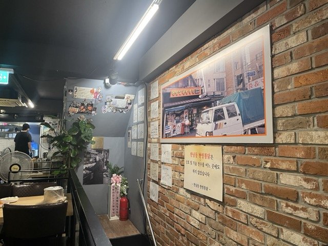 옛 사진과 손글씨 메모가 붙은 가게 벽면