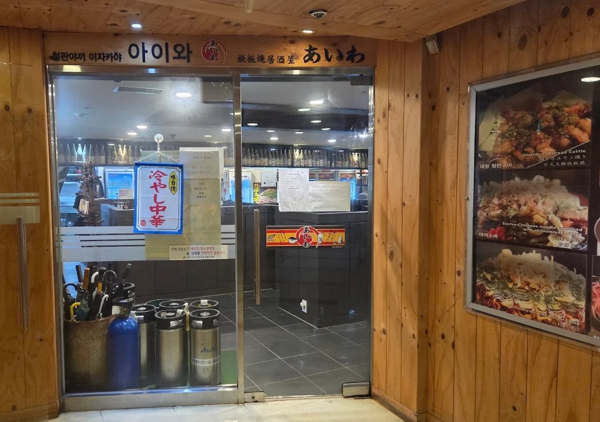 나무 벽과 유리문으로 된 지하 이자카야 입구